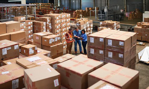 People working together in a warehouse full of boxes