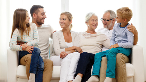 three generations sitting together on a couch